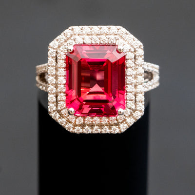 טבעת בעיצוב אישי משובצת אבן חן ספיר בצבע אדום בחיתוך אמרלד עם שני מעגלי יהלומים מסביב