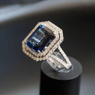 טבעת יוקרתית בשיבוץ אבן חן ספיר כחולה בחיתוך אמרלד עם שני מעגלי יהלומים