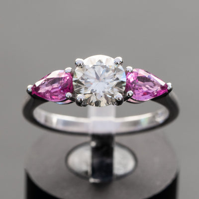 טבעת אירוסין מושלמת משובצת יהלום מרכזי במשקל 1 קראט ובצדדיו 2 אבני חן ספיר טבעיות בצבע ורוד