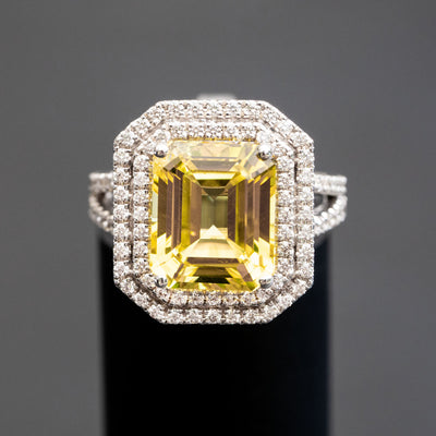 טבעת משובצת אבן חן ספיר בצבע צהוב חיתוך אמרלד משובצת שני מעגלי יהלומים מסביב