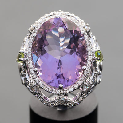 טבעת בעיצוב ייחודי משובצת אבן חן אמטיסט טבעית בצבע סגול מהמם יחד עם אבני חן פרידוט בצבע ירוק ויהלומים טבעיים מסביב